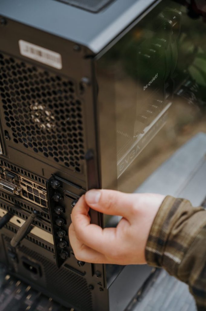 Close-up of hands cleaning and maintaining a desktop computers internal hardware.
